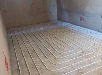 Hydronic underfloor heating pipes fastened onto a cured SUNPERL perlite screed substrate, ready for final floor finish
