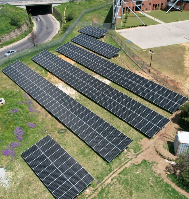 Aerial view of a Synergy-installed commercial ground-mount solar PV array in South Africa, custom-sized to fit the available land alongside a corporate site